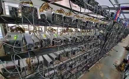 A well-maintained cryptocurrency mining farm with rows of mining rigs.